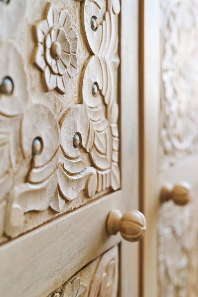 détail armoire en bois gravée dans chambre Airbnb