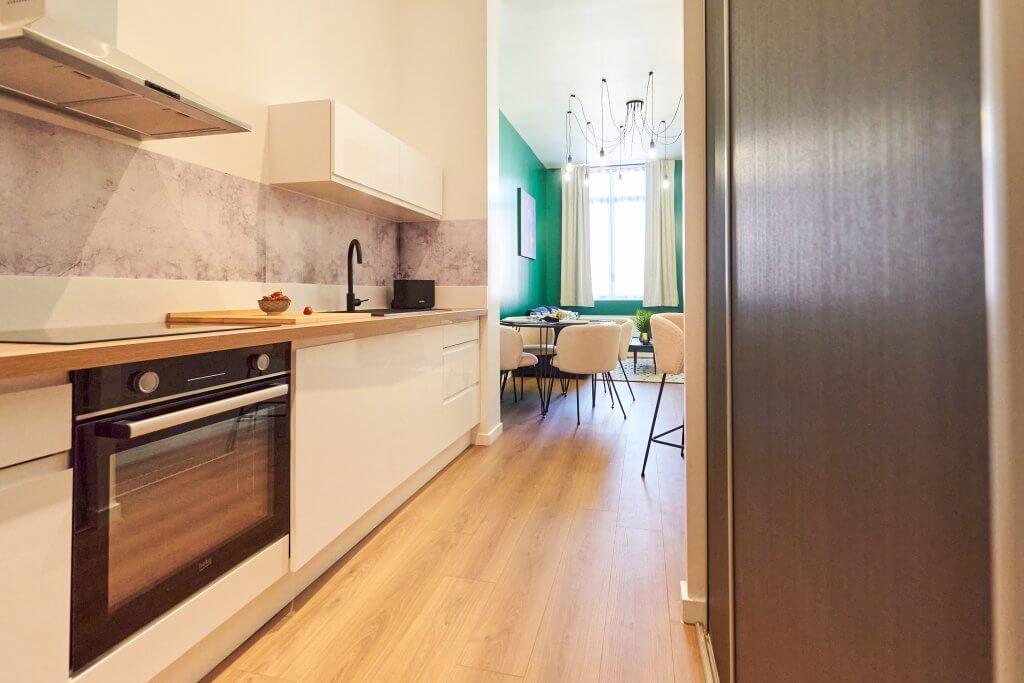Cuisine et entrée Airbnb avec séjour en arrière plan