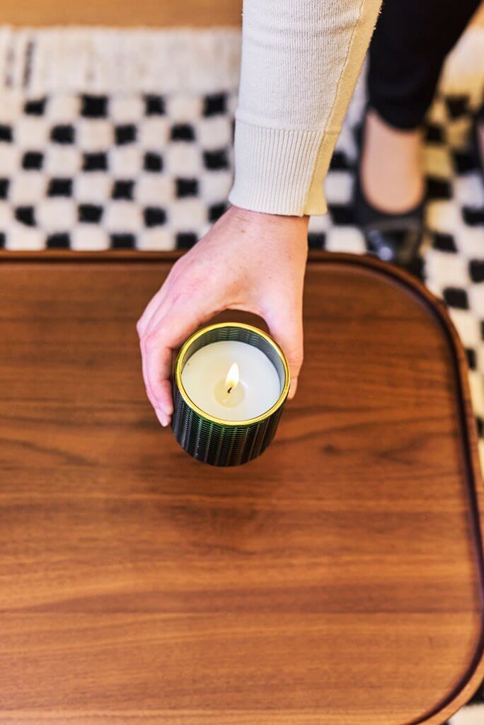 Femme déposant bougie sur table basse dans Airbnb