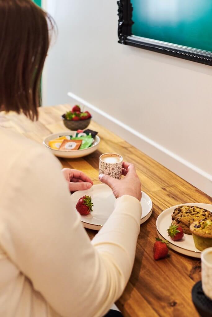 Femme prenant son petit déjeuner sur coin café dans cuisine Airbnb