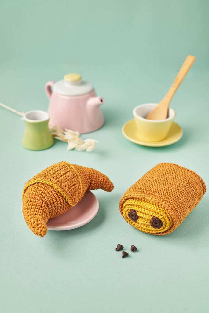 Croissant et pain au chocolat au crochet sur fond turquoise avec dinette pastel