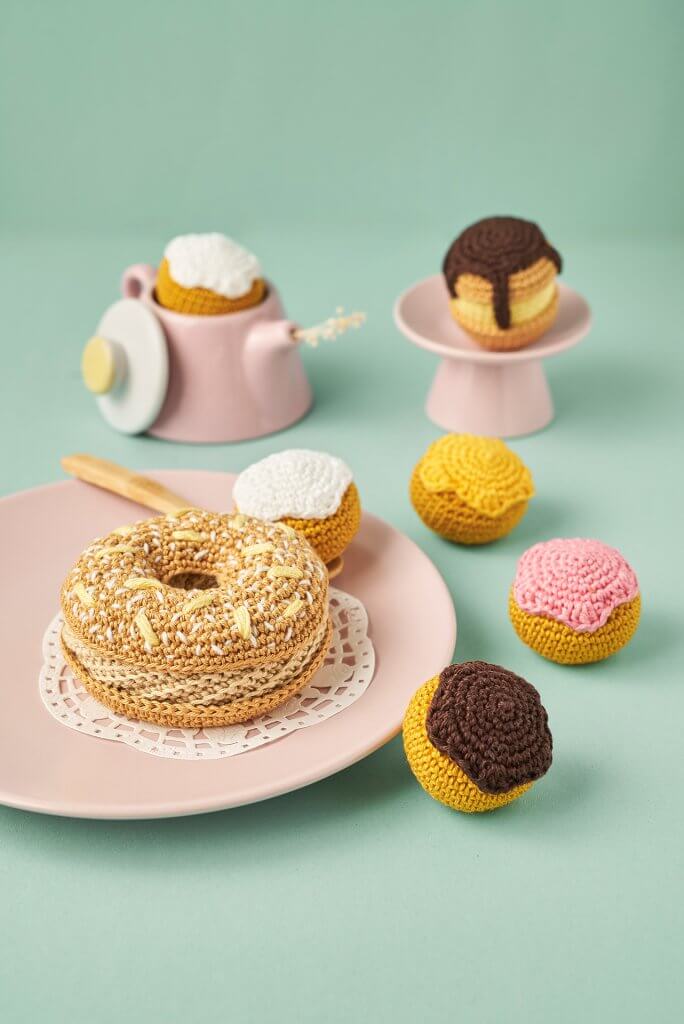 Pâtisseries au crochet mises en scène dans dinette pastel sur fond turquoise